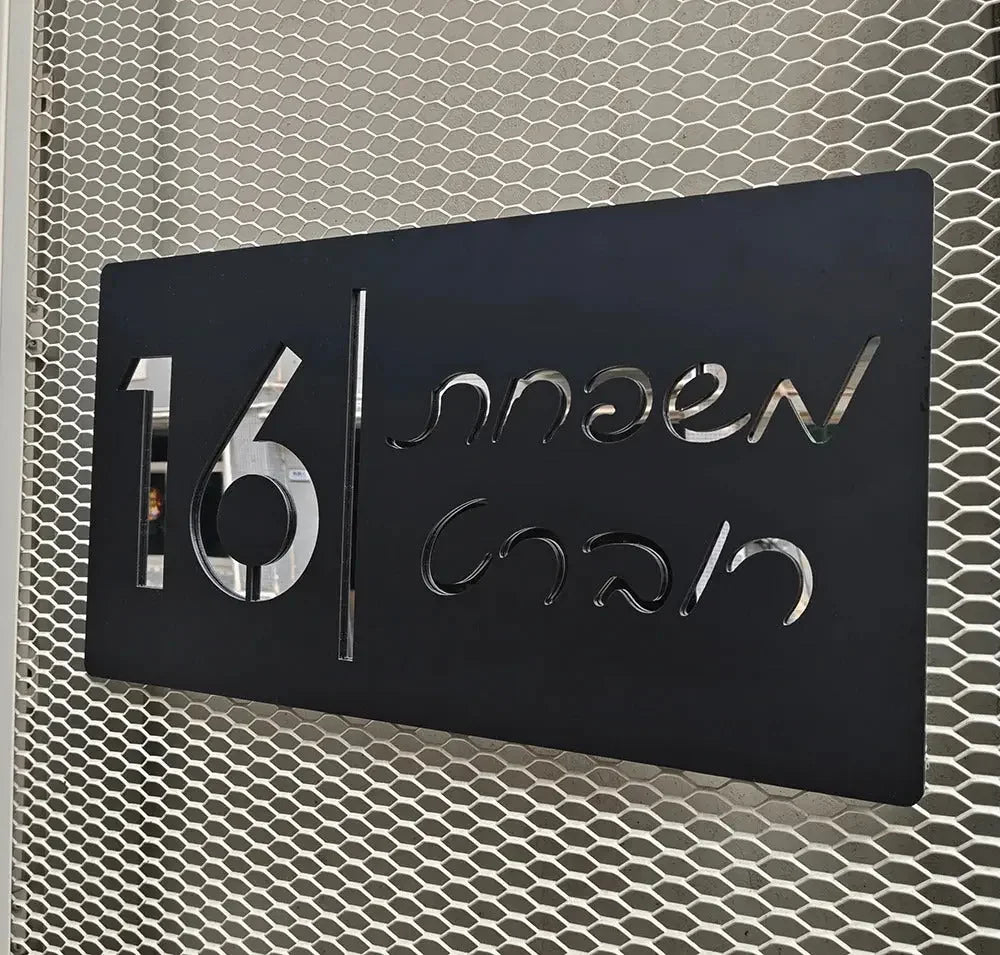 Modern black metal sign with cutout numbers and script text on hexagonal mesh background