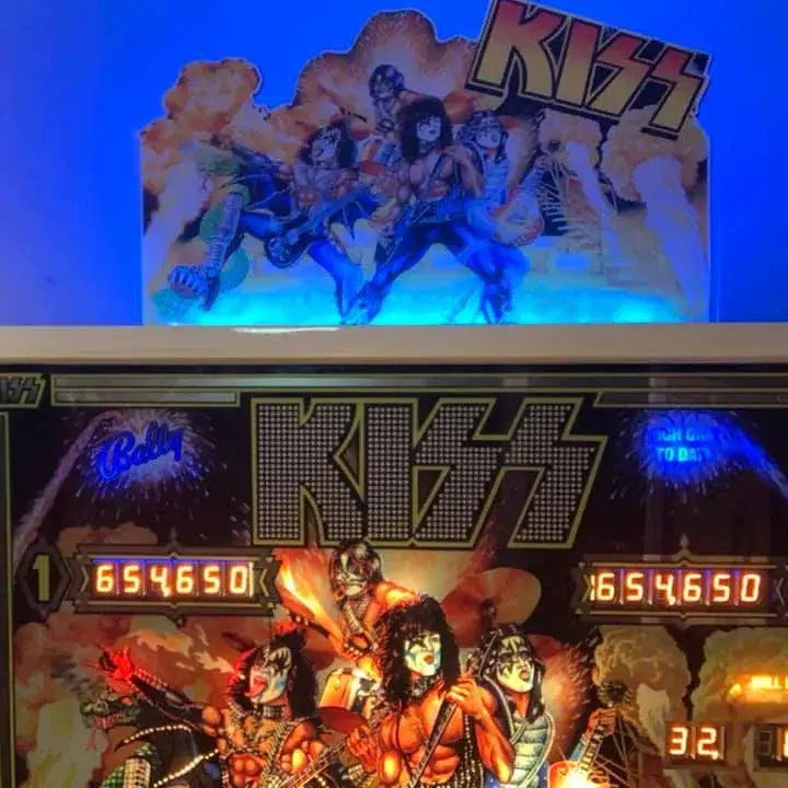 Woman in front of a KISS-themed pinball machine with colorful graphics and 'Kiss' branding.
