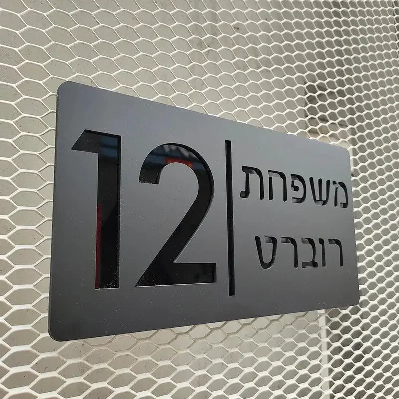 Modern metal address plaque with Hebrew text and number 12 on hexagonal mesh background