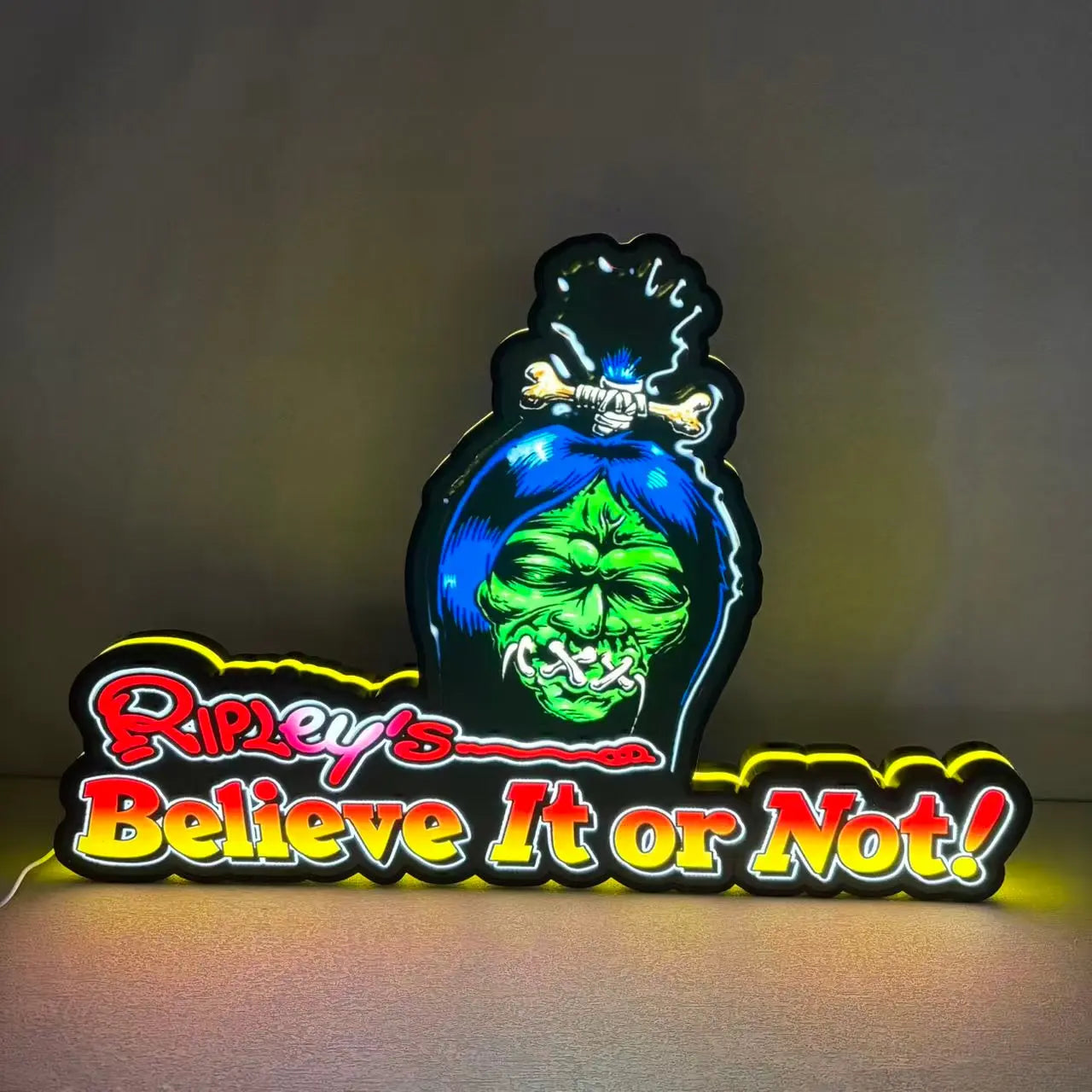 Neon sign with Ripley's Believe It or Not logo on a dark background
