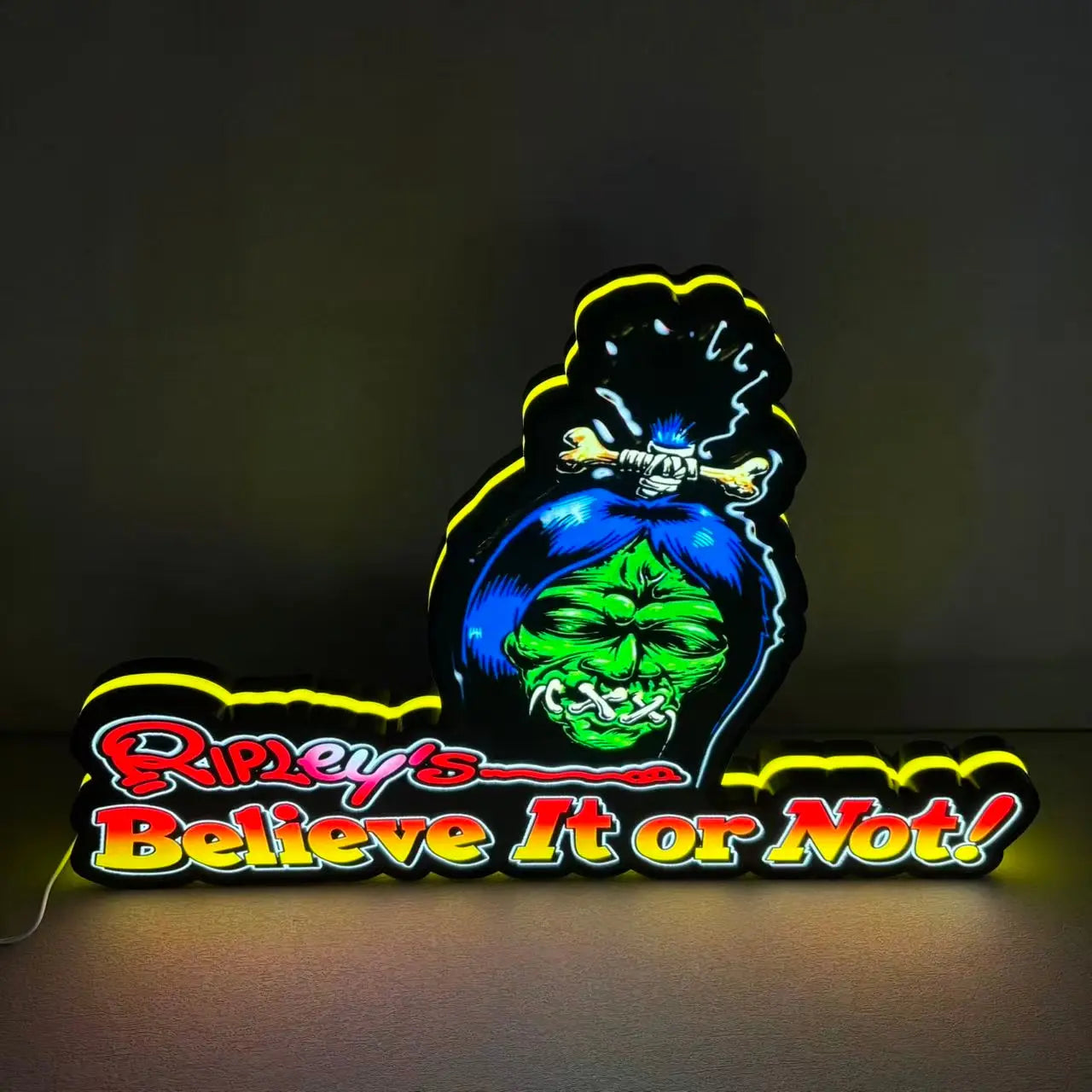 Neon sign with a skull design and 'Ripley's Believe It or Not!' text on a dark background