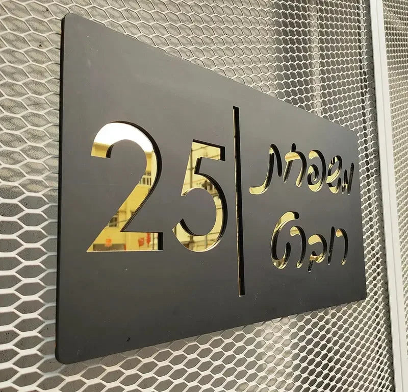 Modern black sign with gold cutout numbers 25 and Thai text, mounted on mesh wall