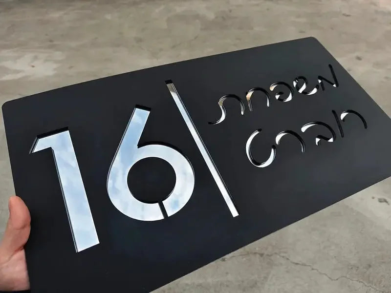 Black custom address plaque with cutout numbers 16 and script text, modern metal design